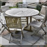 L04. Gloster teak patio set with round table and 6 chairs. 